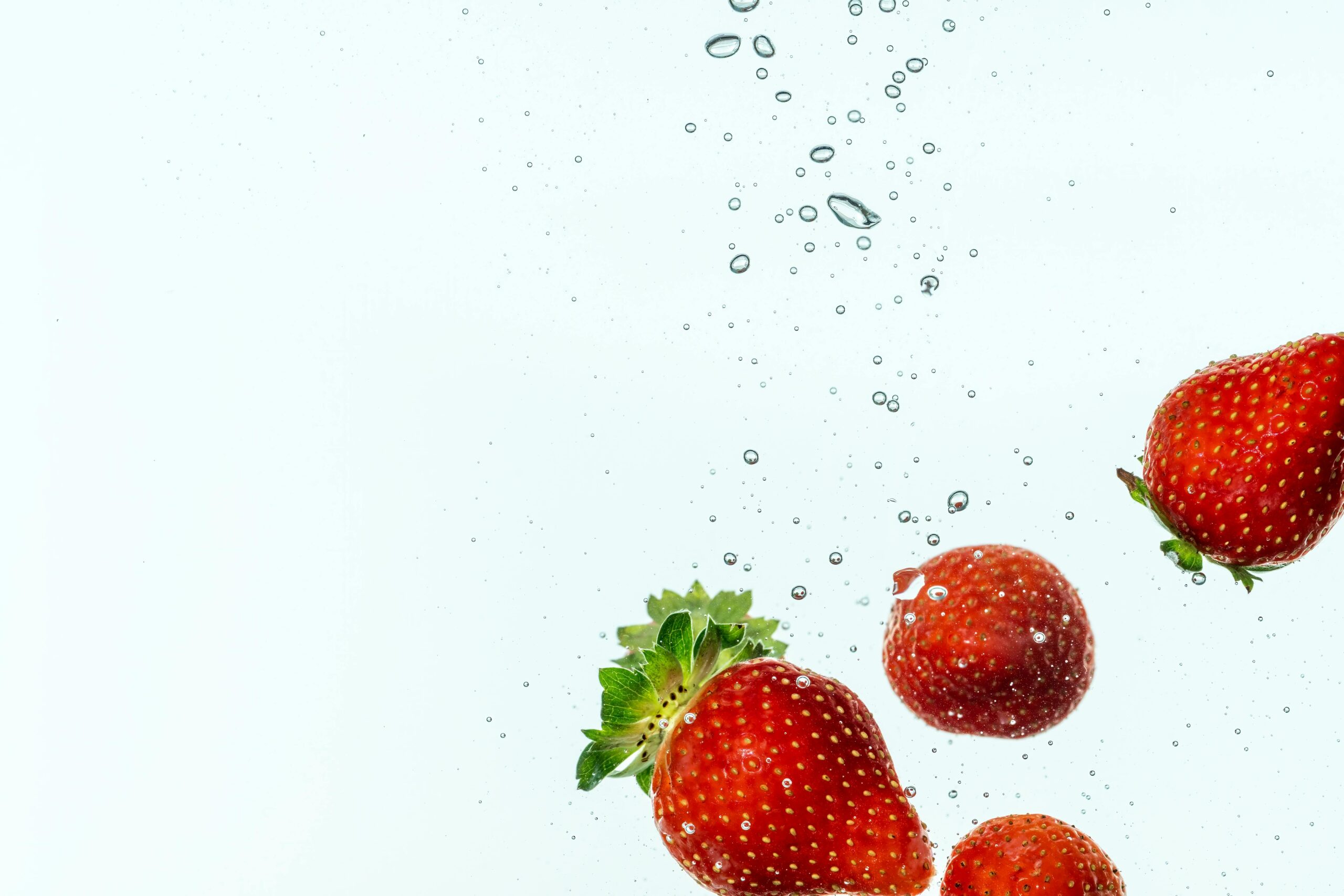 Leuchtende Erdbeeren im Wasser, die Frische und Bewegung ausstrahlen.